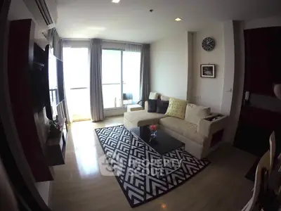 Modern living room with stylish decor and natural light, featuring a cozy sofa and chic rug.