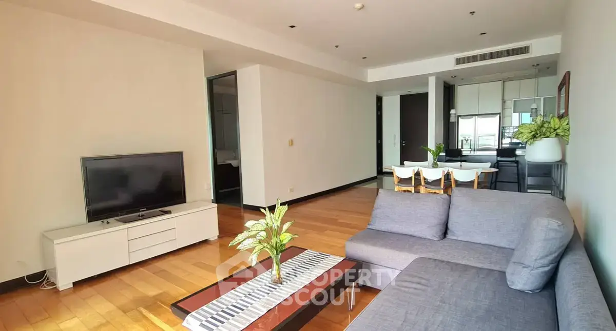 Spacious modern living room with wooden flooring and stylish furniture in a contemporary apartment.