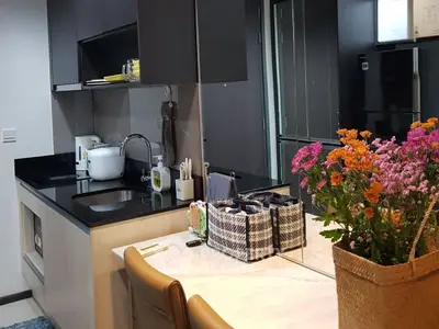 Modern kitchen with sleek black countertops and vibrant flowers, perfect for culinary enthusiasts.
