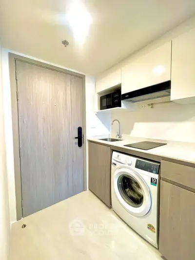 Modern compact kitchen with washing machine and sleek cabinetry