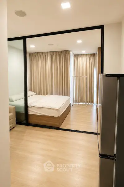 Modern bedroom with glass partition and cozy decor in a stylish apartment.