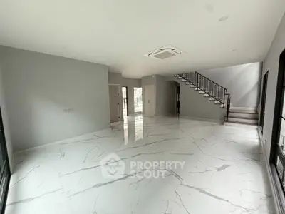 Spacious modern living room with marble flooring and staircase in luxury home