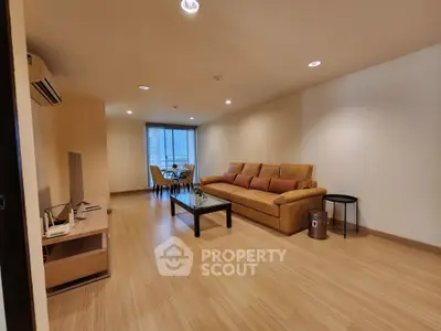 Spacious modern living room with elegant wooden flooring and cozy seating area.