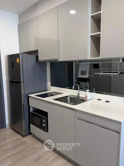 Modern kitchen with sleek cabinetry and stainless steel appliances in a contemporary apartment.