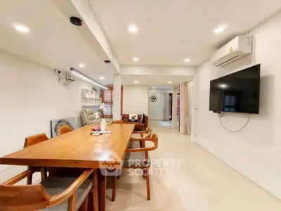 Spacious modern living room with dining area and wall-mounted TV, perfect for family gatherings.