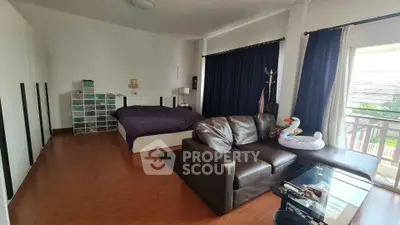 Spacious bedroom with cozy seating area and balcony access