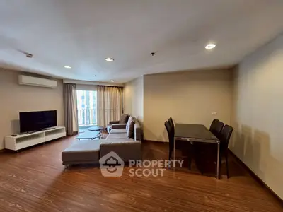 Spacious living room with modern furniture and large windows in a stylish apartment.