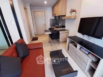 Modern living room with sleek furniture and open kitchen layout in stylish apartment.