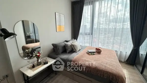 Modern bedroom with large windows and stylish decor, offering a cozy and inviting atmosphere.