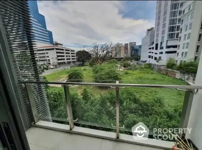 Spacious balcony with lush green view in urban setting