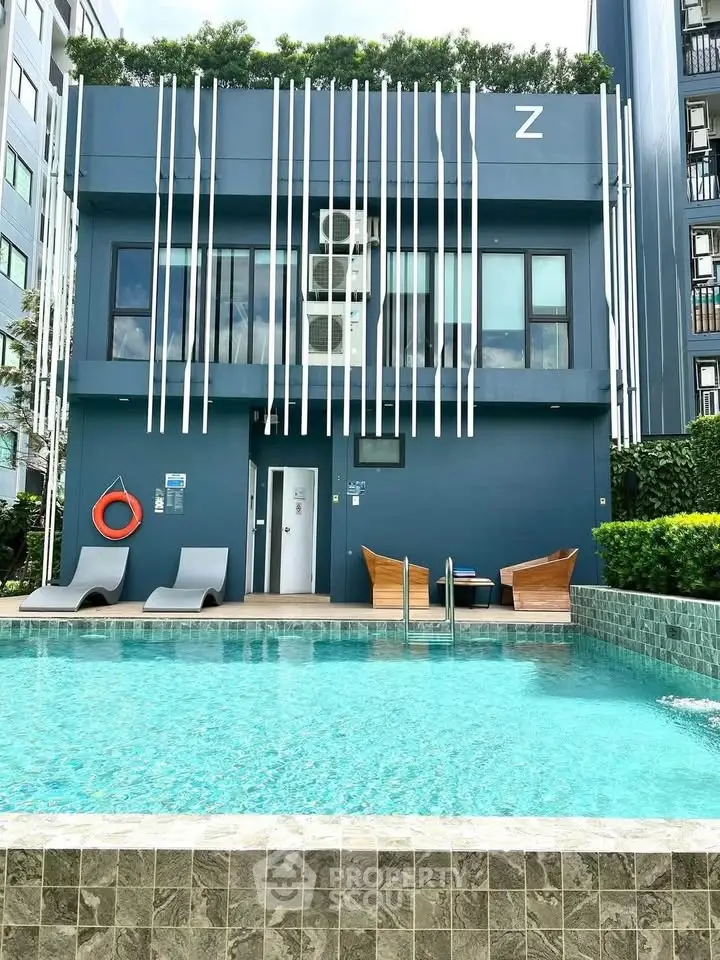 Modern apartment building with pool and stylish outdoor seating area.