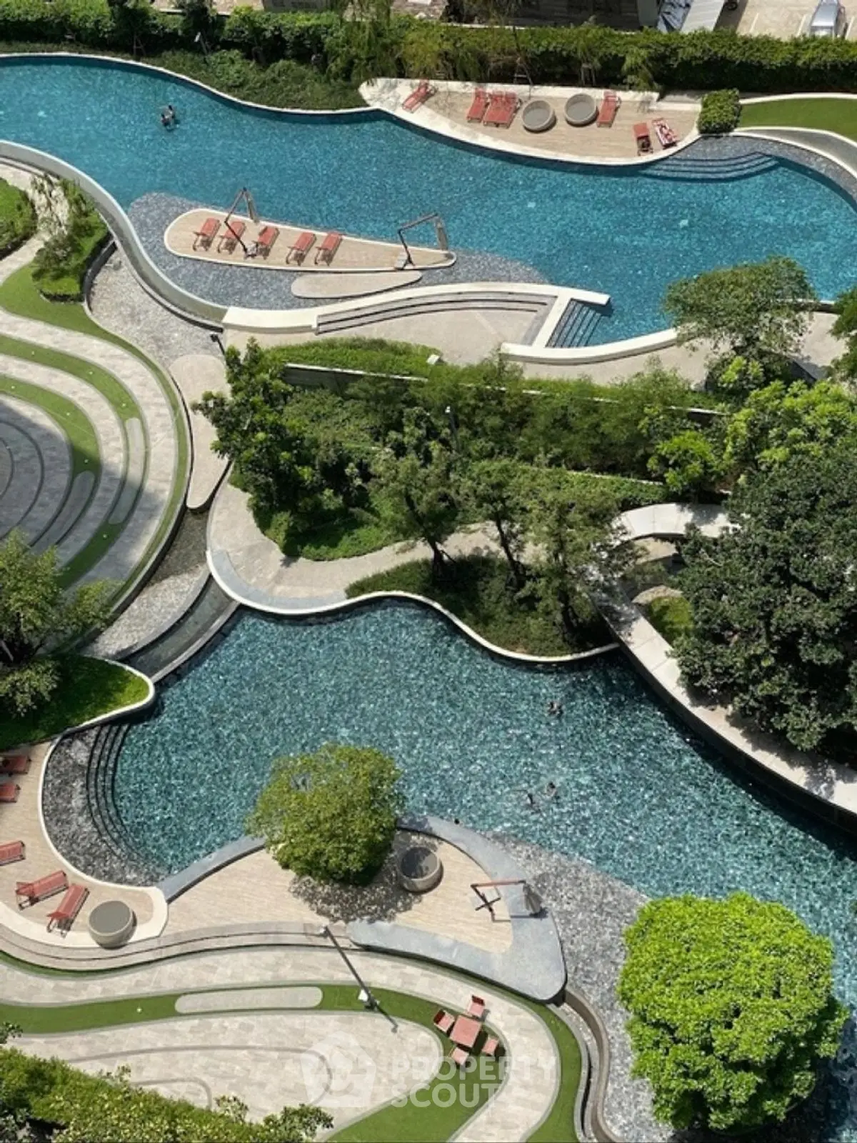 Luxurious aerial view of a modern swimming pool with lush greenery and stylish sun loungers.
