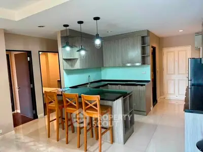 Modern kitchen with island and stylish lighting in open layout apartment.