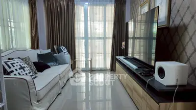 Elegant living room with modern decor, large TV, and stylish sofa, perfect for relaxation and entertainment.