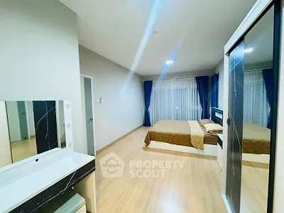 Spacious bedroom with modern decor and large windows for natural light.