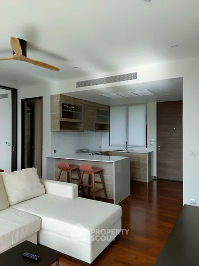 Modern open-layout living room with sleek kitchen and wooden flooring