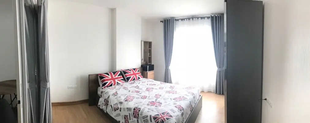 Bright and cozy bedroom with stylish decor and large window for natural light.