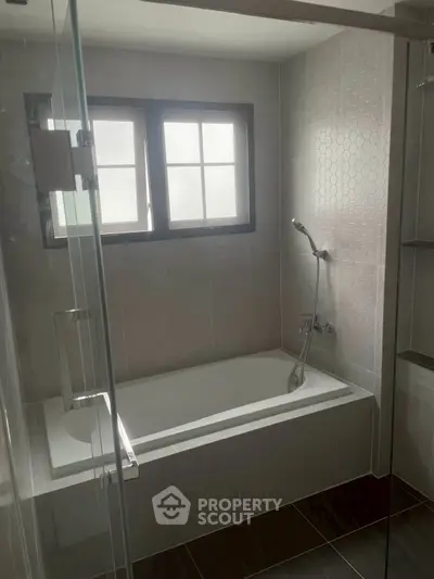 Modern bathroom with sleek bathtub and glass shower enclosure