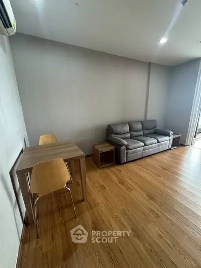 Modern living room with wooden flooring and sleek furniture in a cozy apartment.