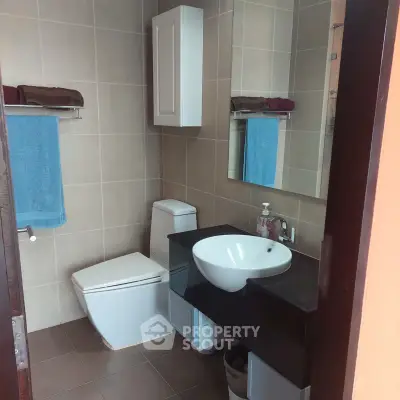 Modern bathroom with sleek fixtures and elegant design, featuring a stylish sink and spacious layout.