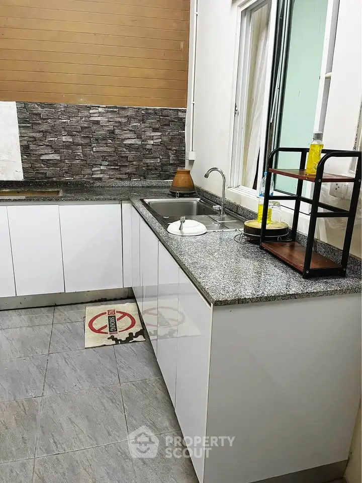 Modern kitchen with sleek countertops and stylish backsplash in a contemporary home.