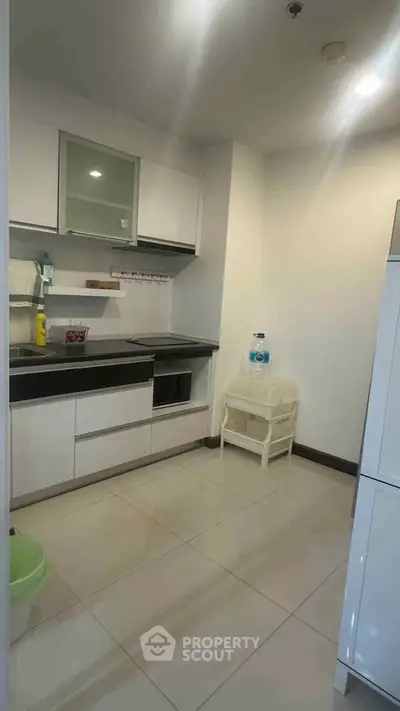 Modern kitchen with sleek cabinetry and tiled flooring, featuring a compact design ideal for urban living.