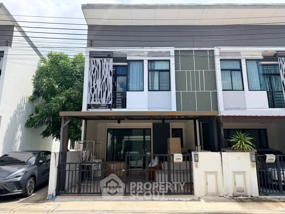 Modern townhouse exterior with carport and stylish facade in a suburban neighborhood.