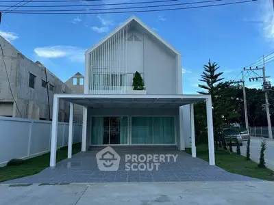Modern minimalist house with spacious carport and sleek facade under clear blue sky.