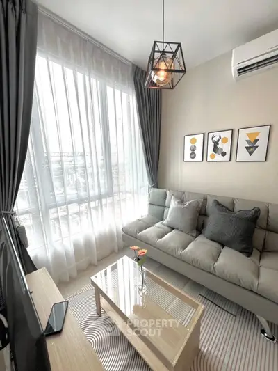 Modern living room with stylish decor, large window, and cozy seating area.