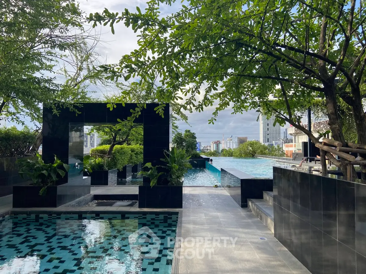 Luxurious rooftop pool with stunning city views and lush greenery, perfect for relaxation and leisure.