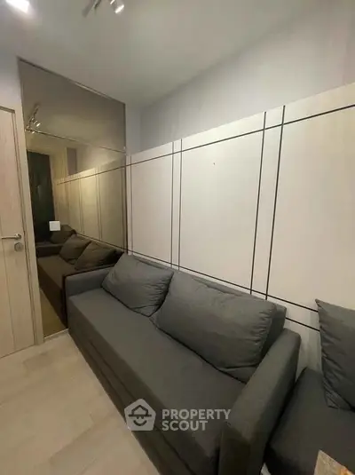 Modern living room with sleek design and comfortable gray sofa, perfect for relaxation.