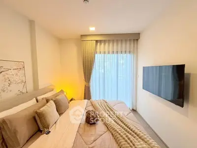 Cozy bedroom with modern decor and wall-mounted TV, featuring soft lighting and elegant curtains.