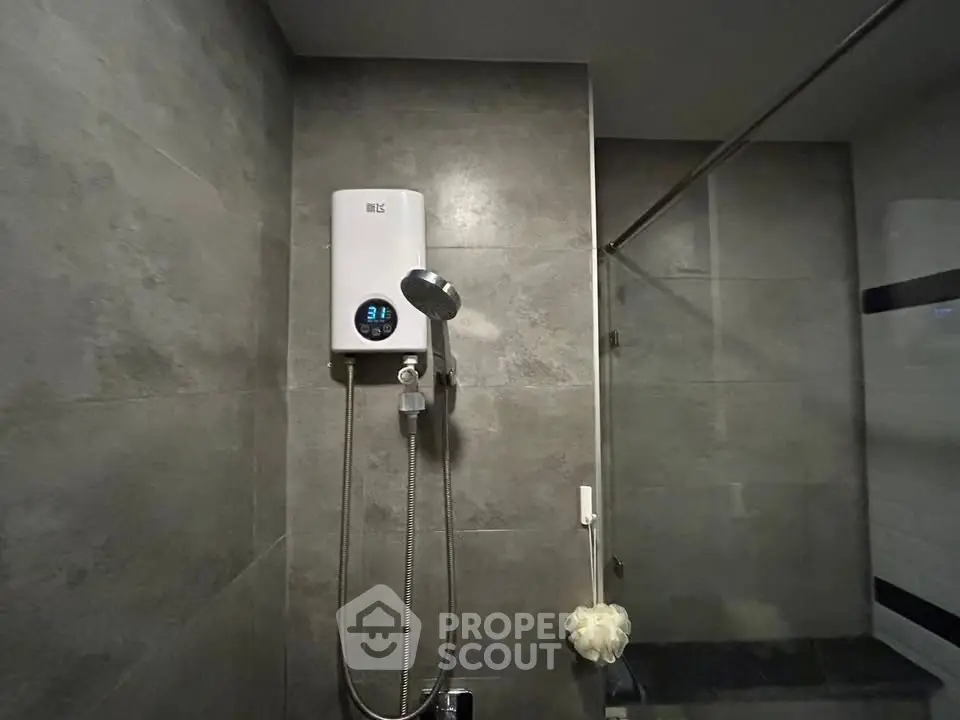 Modern bathroom with sleek shower and water heater in stylish gray tiles.