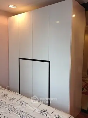 Modern bedroom with sleek white wardrobe and stylish bedding