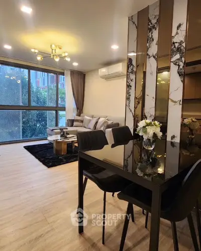 Modern living room with elegant decor and large windows offering natural light.