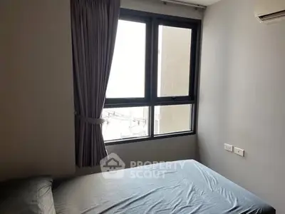 Cozy bedroom with large window and modern air conditioning unit.