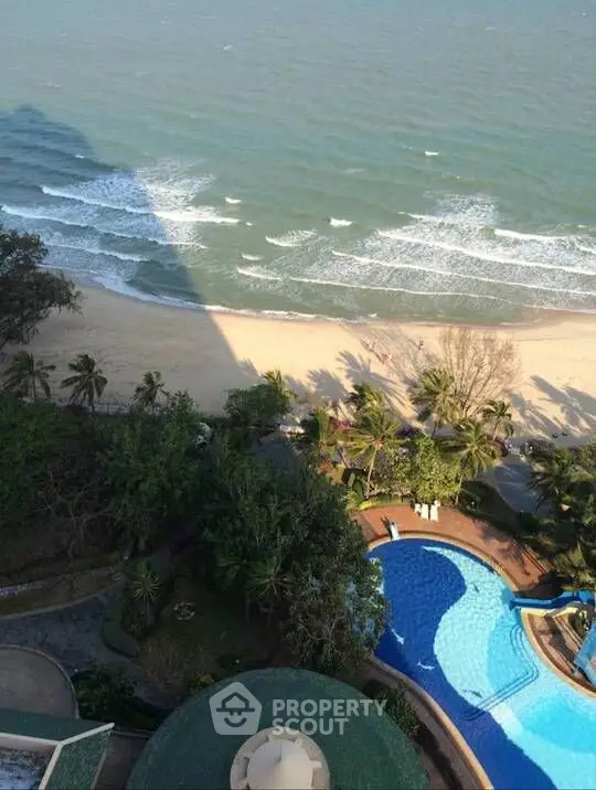 Stunning beachfront view with pool and lush greenery, perfect for luxury living.