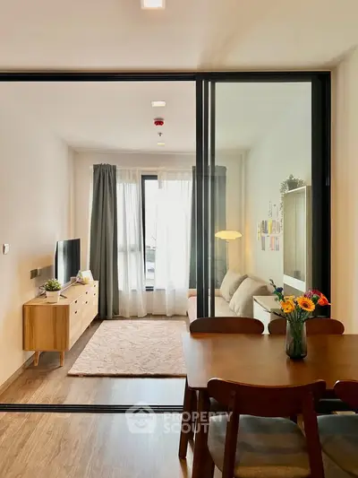 Modern living room with glass partition, cozy sofa, and stylish decor in a bright apartment.