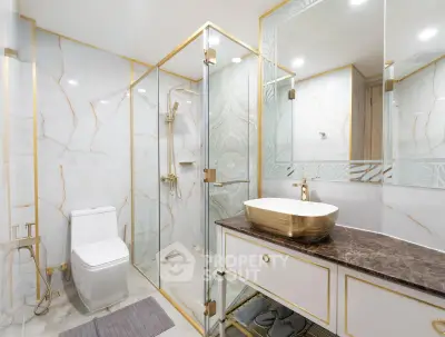 Luxurious bathroom with marble walls, glass shower, and elegant gold fixtures.