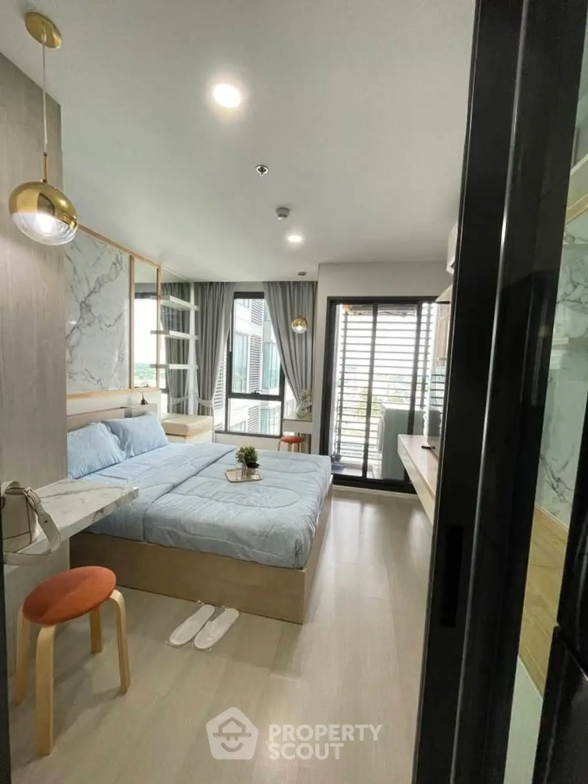Modern bedroom with stylish decor and balcony access in a contemporary apartment.