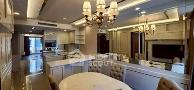 Luxurious open-plan kitchen and dining area with elegant lighting and mirrored walls.