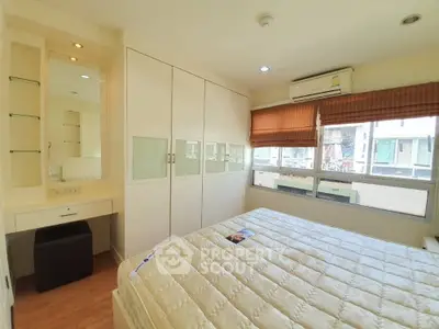 Spacious bedroom with large bed, mirrored wardrobes, and ample natural light streaming through generous windows, complemented by warm curtains.