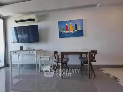 Modern living room with sleek furniture and vibrant sailboat artwork, featuring a wall-mounted TV and air conditioning.