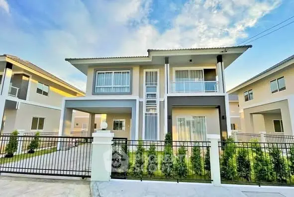 Modern two-story house with large windows and a well-maintained garden.