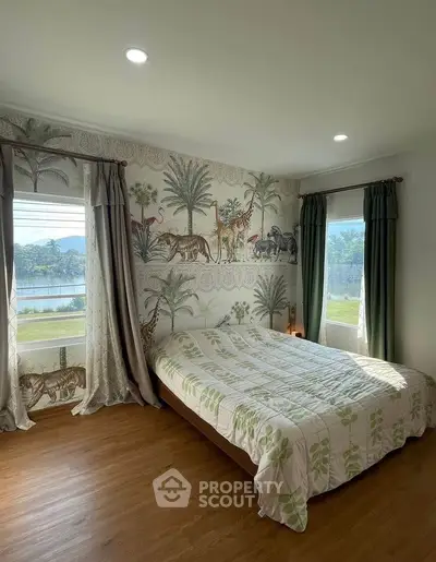 Charming bedroom with nature-themed wallpaper and scenic window view