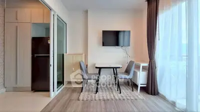 Modern living room with TV, dining table, and large window for natural light.