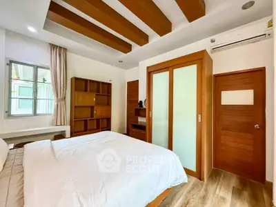 Spacious bedroom with modern wooden accents and ample natural light