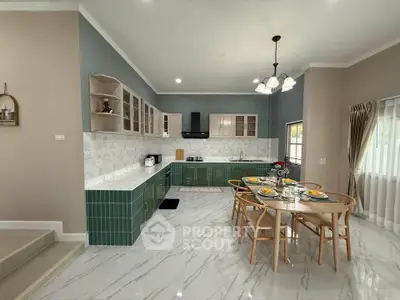 Spacious modern kitchen with green cabinets and elegant dining area, perfect for family gatherings.