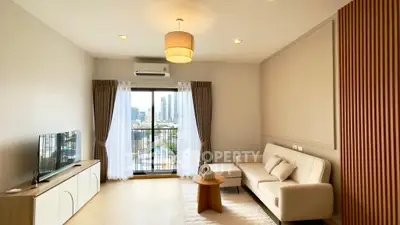 Modern living room with city view, elegant decor, and natural light.