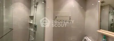 Modern bathroom with glass shower and sleek fixtures in a contemporary apartment.